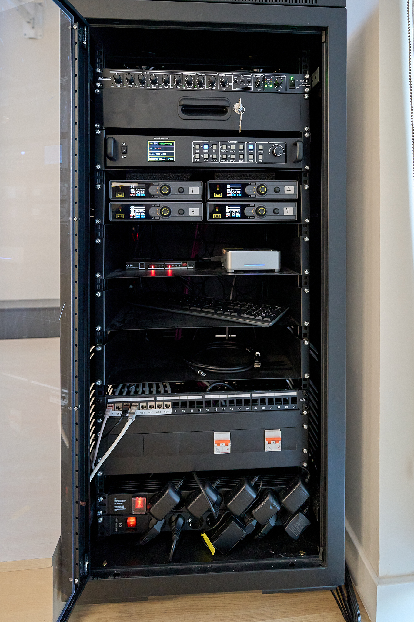 GETD - Detalle de mueble rack con sistemas avanzados de control de audio y micrófonos del auditorio.